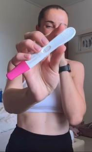Woman holding a positive pregnancy test.