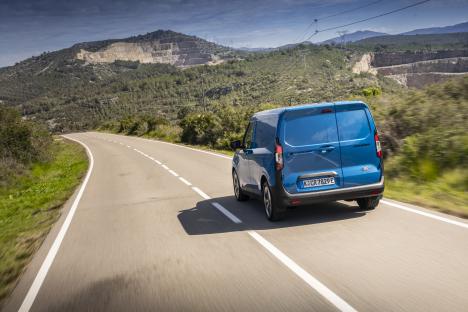 Blue van driving on a road.