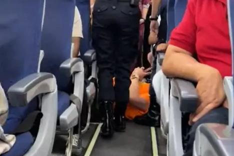 Moment bulky passenger who demanded aisle seat for his big frame is DRAGGED off jet wearing ‘too busy doing nothing’ top