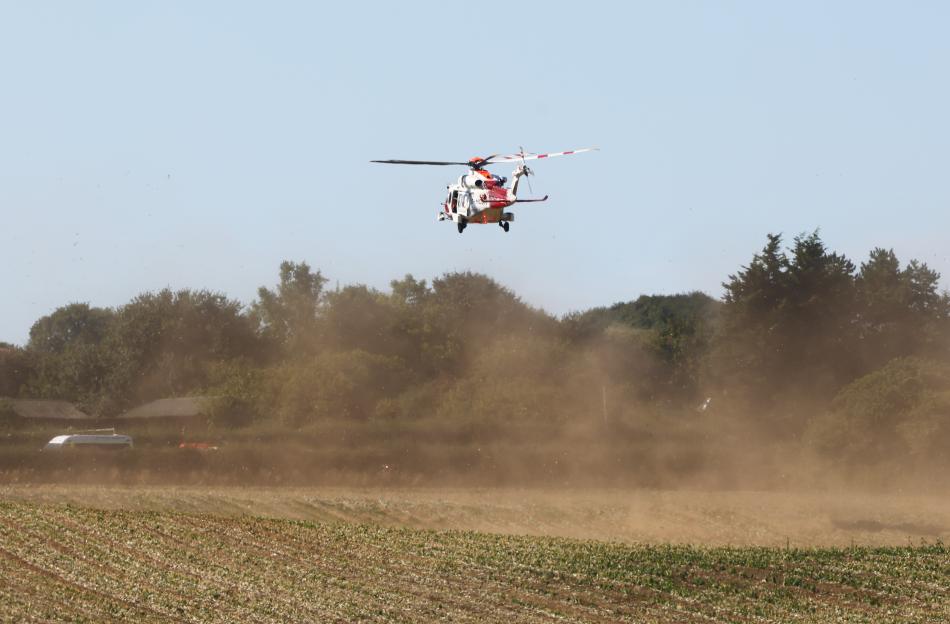 Rescue helicopter in flight over a field.