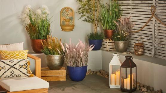 Aldi outdoor patio scene with plants in copper, silver, and blue pots, and lanterns.