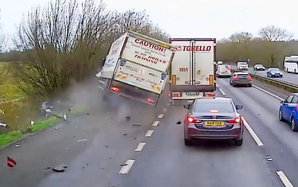 A lorry crashes into cars on the side of a highway.