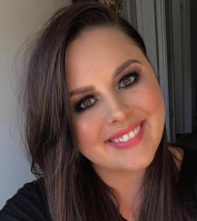 Portrait of a woman with long brown hair and makeup.