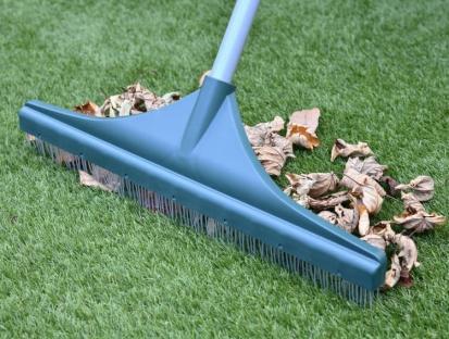 Telescopic artificial grass rake raking leaves.