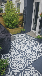 a patio with a black and white pattern on the floor
