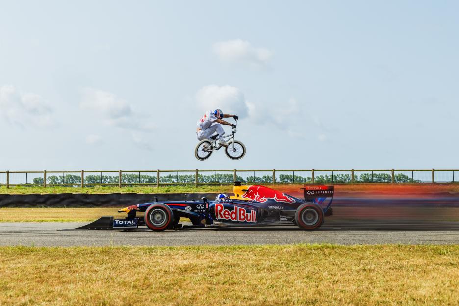 Kriss Kyle jumps over a Red Bull Racing car driven by David Coulthard during 'Can He Hop It' at Goodwood Motor Circuit in Chichester, United Kingdom on July 14, 2025. EDITORIAL NOTE: MULTIPLE SEQUENCE PICTURES WERE USED TO COMPOSE THIS IMAGE. / Dan Griffiths / Red Bull Content Pool / SI202508050317 / Usage for editorial use only /
