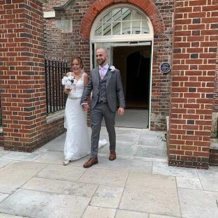 A newly married couple leaving a building.