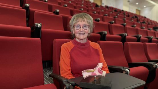 Professor Jill Belch sitting in a lecture hall.