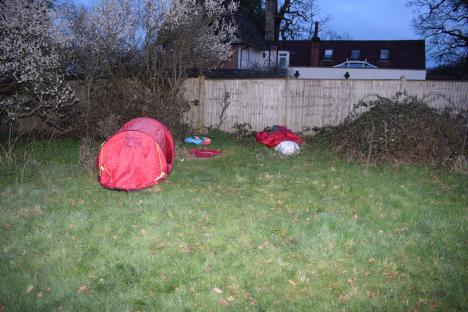 Red tent in a backyard.