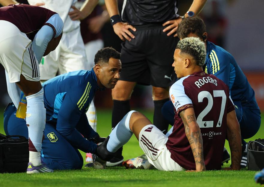 Aston Villa's Morgan Rogers receives medical attention on the field.