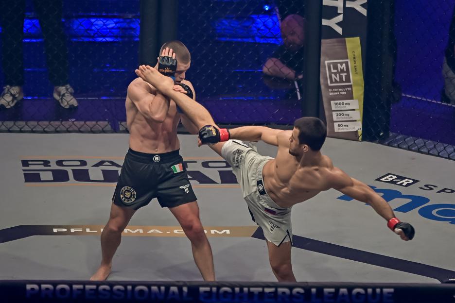 Russia's Usman Nurmagomedov (white) fights Ireland's Paul Hughes (black) during a lightweight title fight.