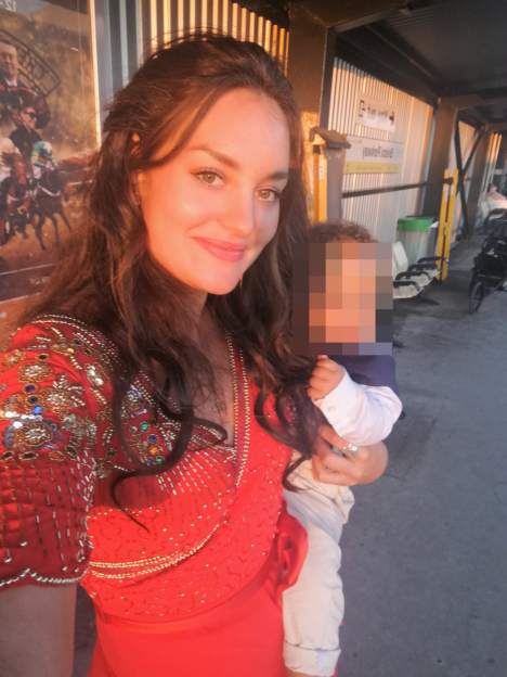 Woman in red dress holding a child.