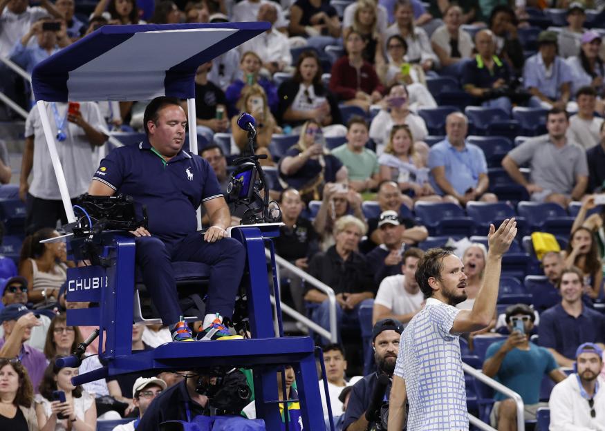 Daniil Medvedev speaking to the referee during a tennis match.