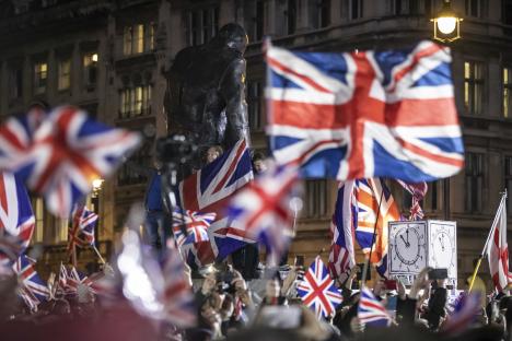 Pro-Brexit supporters celebrating in Parliament Square with Union Jack flags.