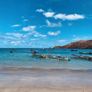 Tropical beach scene with boats in the water.
