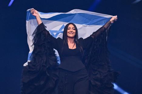 Yuval Raphael holding Israeli flag at Eurovision Song Contest.
