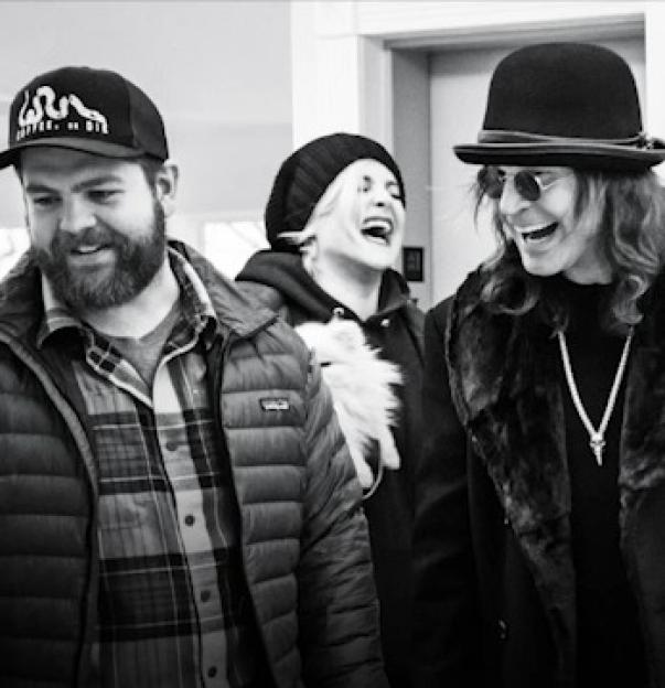 Black and white photo of Jack Osbourne, his sister, and a friend laughing.