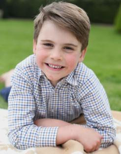 Portrait of a smiling young boy lying on his stomach.