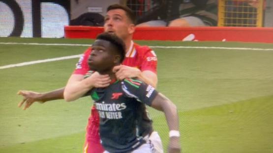 Soccer player being choked by another player.