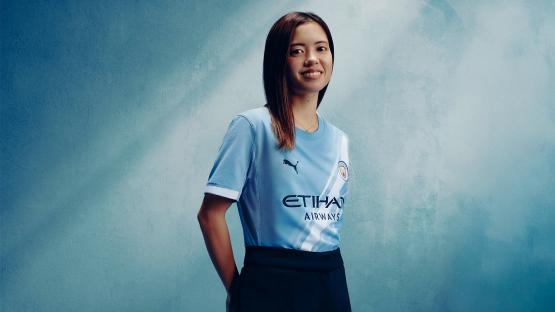 Woman in Manchester City jersey.