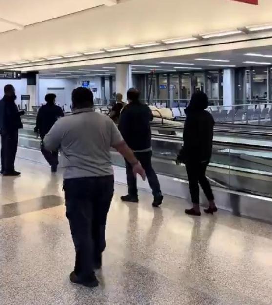 People watching a drunk passenger steal an airport golf cart.
