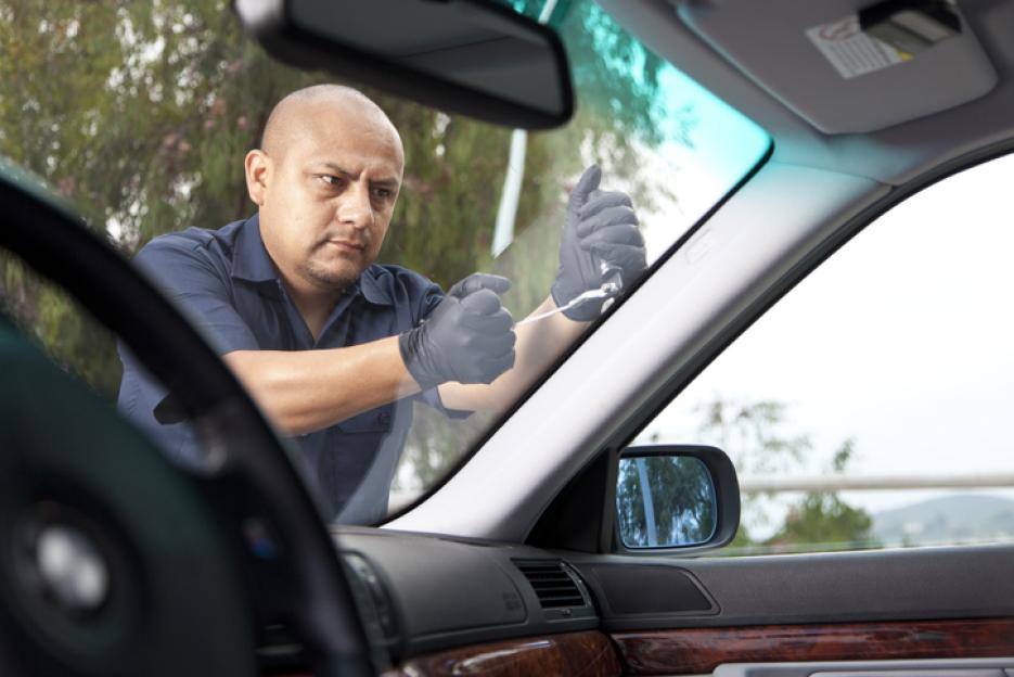 Man repairing a car windshield.