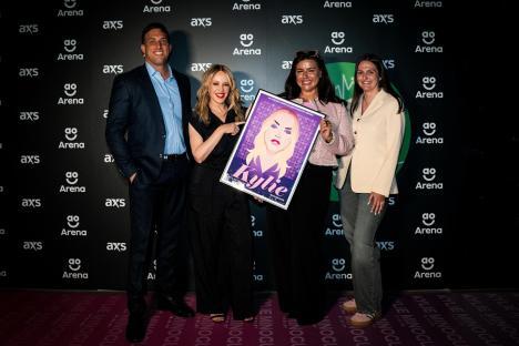 Kylie Minogue holding a commemorative plaque for being the most performed female artist at an arena.