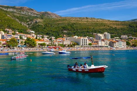 Petrovac beach in Montenegro with boats and people.