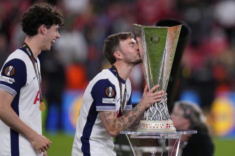 James Maddison of Tottenham Hotspur kisses the Europa League trophy.
