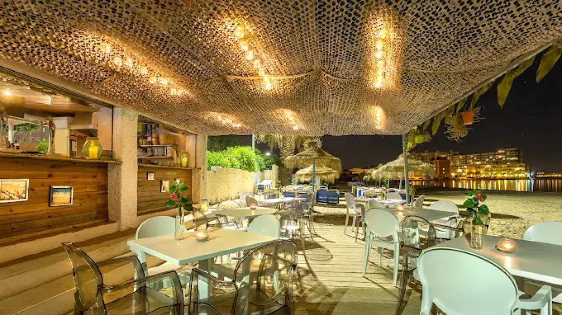 Outdoor restaurant at night on a beach.