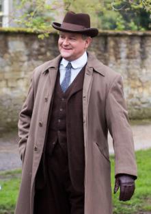 Hugh Bonneville in a brown suit and overcoat on the set of the Downton Abbey film.