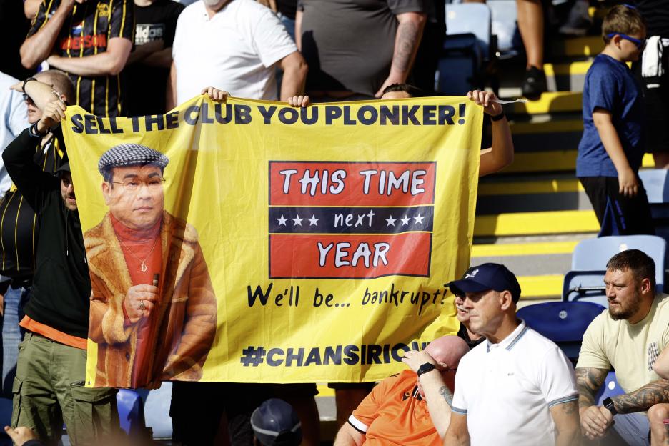Sheffield Wednesday fans hold a banner criticizing owner Dejphon Chansiri.