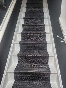 Stair runner made from patterned floor mats.