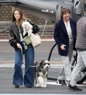 Tom Cruise and Ana de Armas arriving at a heliport with their dogs.