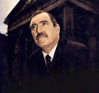 Portrait of a man in a suit in front of a building.