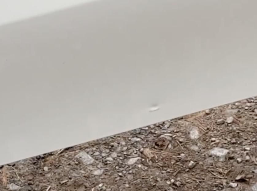Close-up of a dented white car panel.