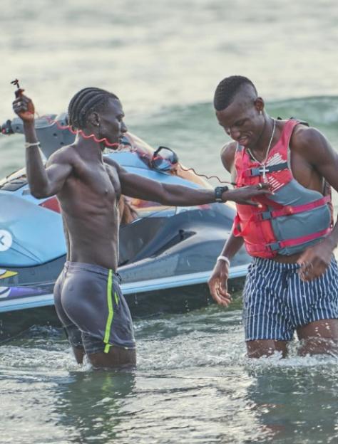 Nicolas Jackson playing beach football and riding a jet ski.