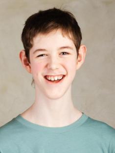 Photo of a smiling autistic teenager.