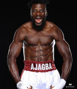 A muscular boxer, Ajagba, with his mouth open.