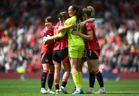 Manchester United women's soccer players celebrating.