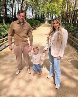 Georgia Kousoulou, Tommy Mallett, and their son Brody walking outdoors.