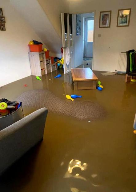A living room floor completely covered in floodwater.