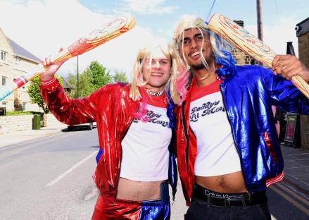 Two men dressed as Harley Quinn holding baseball bats.