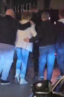 Rod Stewart surrounded by people in an Irish bar.