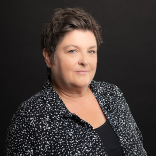 a woman with short hair is wearing a black and white polka dot shirt