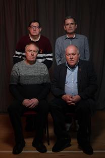 Photograph of four men seated, possibly involved in a British blood scandal.