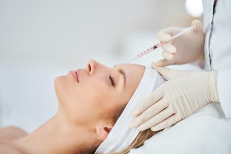 Botox injection being administered to a woman's forehead.
