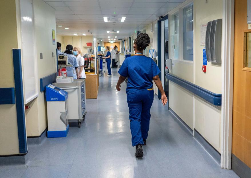 NHS hospital ward with nurses and medical equipment.