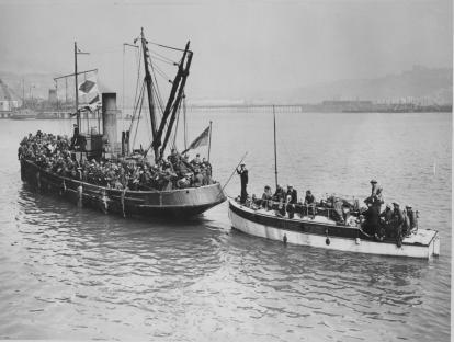 Photo of two small boats carrying soldiers arriving at Dover during World War II.