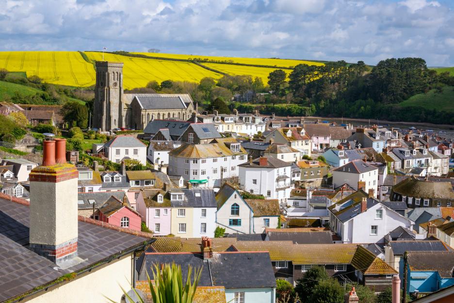 Aerial view of Salcombe, South Devon, with colorful houses and a church.